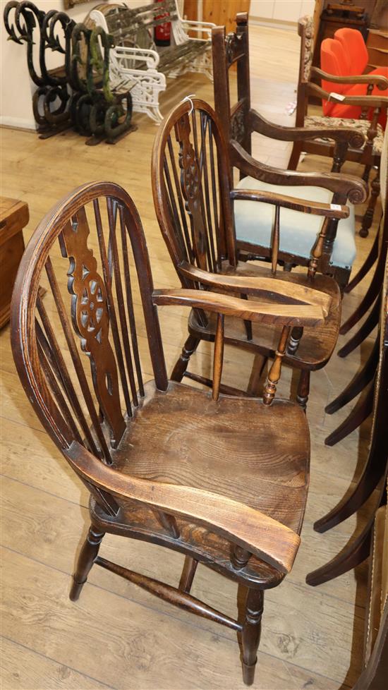 A carved oak framed armchair and a pair of elm and beech wheel back elbow chairs (3)